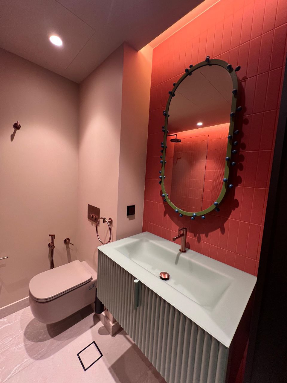 Coral powder room with designer mirror — villa, Emirates Hills
